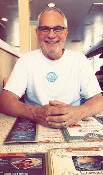 Jim smiling at a restaurant table